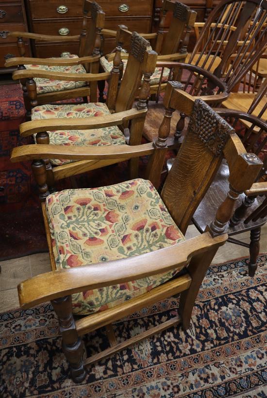 A set of four 1930s carved oak elbow chairs, marked Jas Schoolbred & Co
